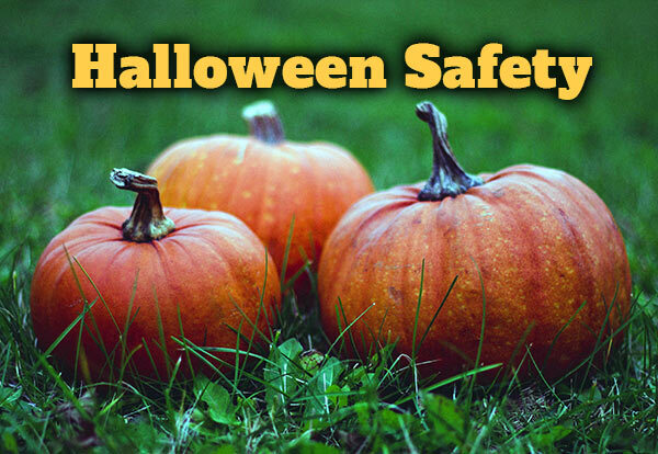 Halloween Safety with 3 pumpkins on grass in the background.