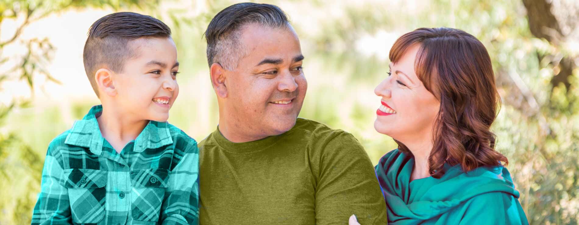 A child and man looking and smiling at a woman.