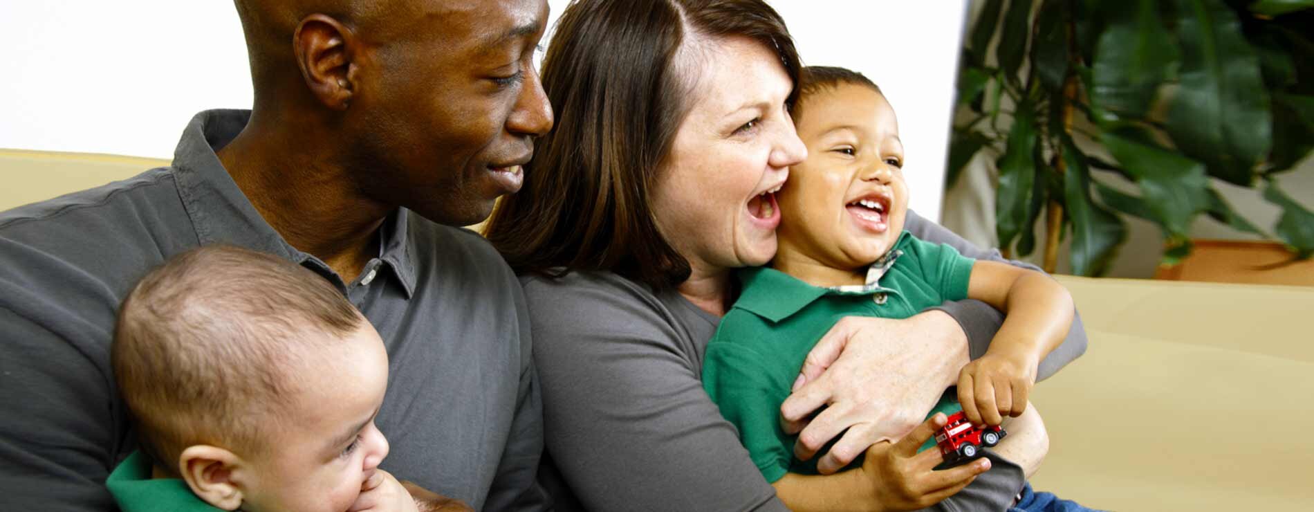 A family of four smiling and laughing.